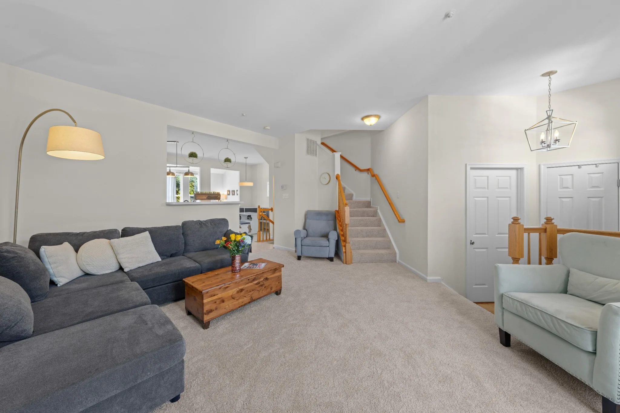 Light-filled living room with seating and staircase
